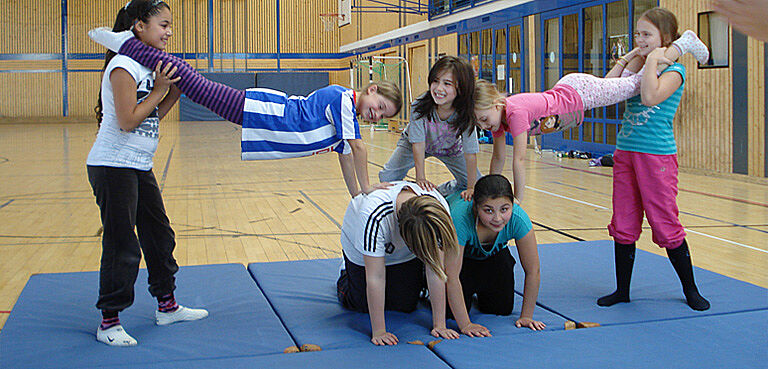 sechs Mädchen machen Akrobatik