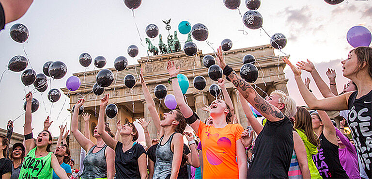 Frauen lassen Luftballons vor dem Brandenburger Tor fliegen