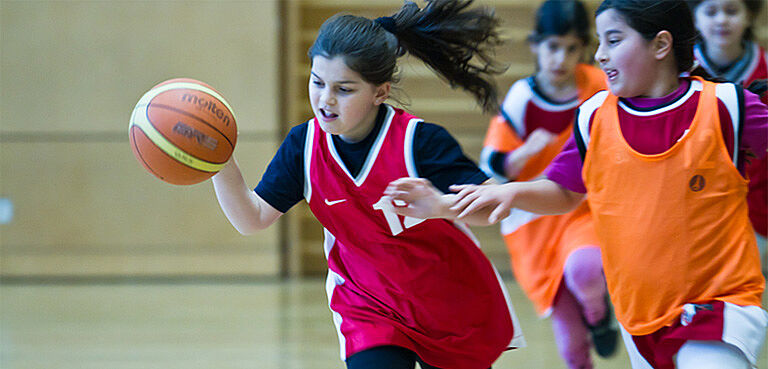 Mädchen spielen Basketball