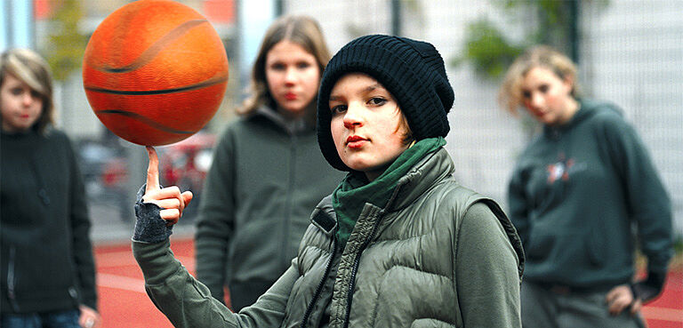 Mädchen mit Basketball auf dem Finger jonglierend