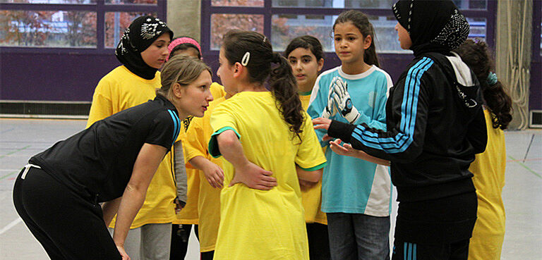 Trainerin spricht mit jungen Mädchen